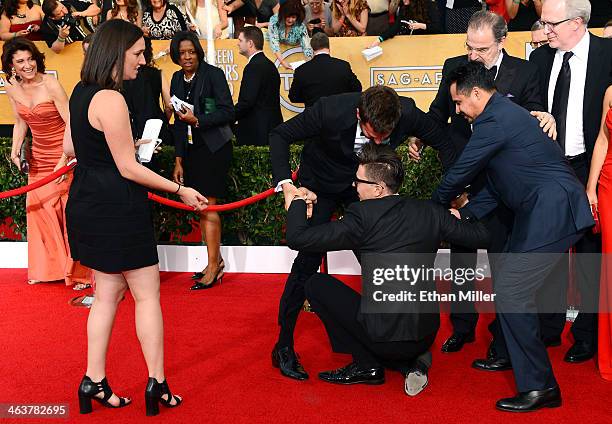 Actor Michael Pena tries to help actor Bradley Cooper remove Ukrainian reporter and prankster Vitalii Sediuk from Cooper's legs on the red carpet at...