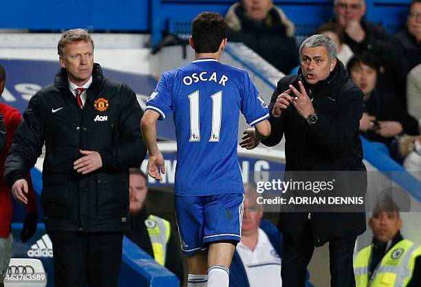 Chelsea's Portuguese manager Jose Mourinho talks with Chelsea's Brazilian midfielder Oscar as Manchester United's Scottish manager David Moyes makes...