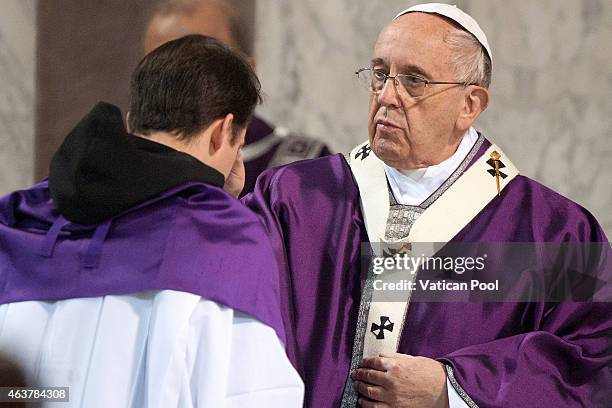 Pope Francis blesses with the ritual placing of ashes on the head of a member of the congregation during the Ash Wednesday service at the Santa...