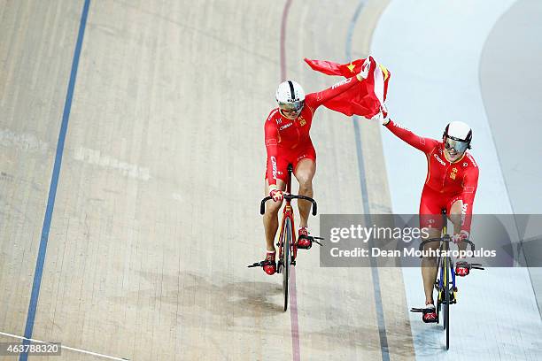 Jinjie Gong and Tianshi Zhong of China Cycling Team celebrate winning the gold medal in the Women's Team Sprint qualifying round as her coach yells...