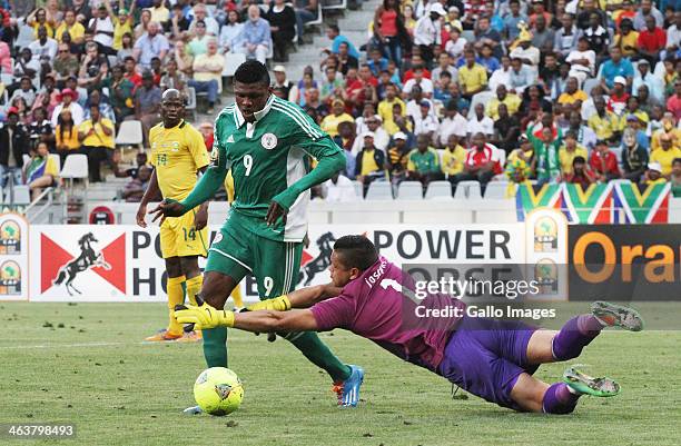 Fuad Salami of Nigeria on the attack as Moeneeb Josephs of South Africa dives for the ball during the 2014 African Nations Championship match between...