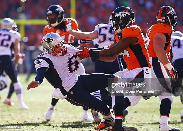 Brandon Marshall of the Denver Broncos collides with Ryan Allen of the New England Patriots in the first quarter during the AFC Championship game at...