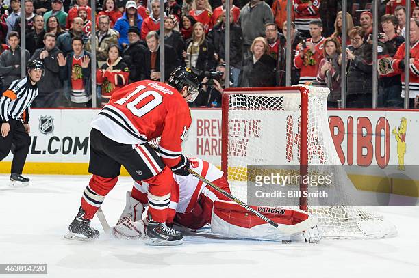 Goalie Jimmy Howard of the Detroit Red Wings blocks the shoot-out shot by Patrick Sharp of the Chicago Blackhawks to win the game 3-2 during the NHL...