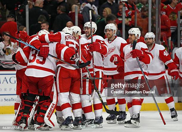 Membes of the Detroit Red Wings mob Jimmy Howard after a shootout win over the Chcago Blackhawks at the United Center on February 18, 2015 in...