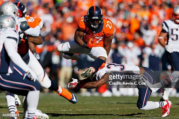 Knowshon Moreno of the Denver Broncos jumps over Duron Harmon of the New England Patriots in the second quarter during the AFC Championship game at...