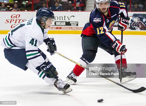 Forward Will Bitten of the Plymouth Whalers battles for the puck against forward Jamie Lewis of the Windsor Spitfires on February 18, 2015 at the...