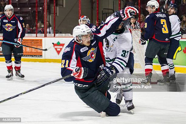 Forward Logan Brown of the Windsor Spitfires is driven to the ice by Gianluca Curcuruto of the Plymouth Whalers on February 18, 2015 at the WFCU...