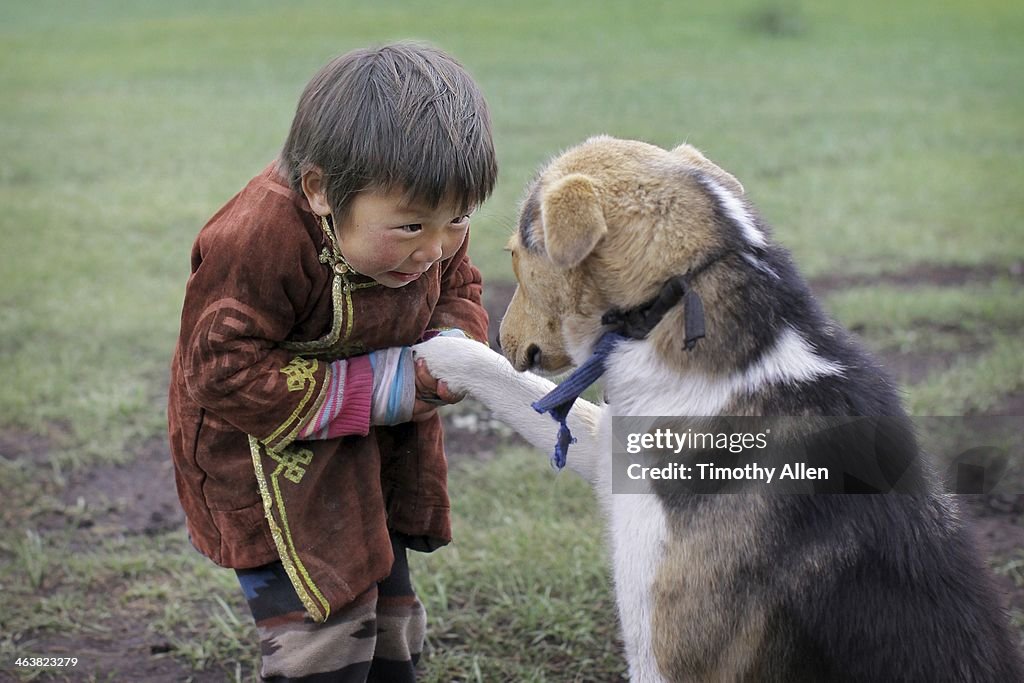 Young Mongolian boy and dog