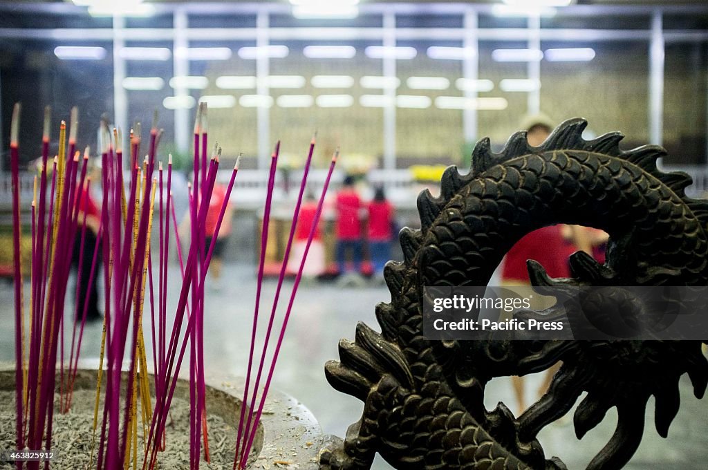 Visitors of the Buddhist Temple in Tondo light their incense...