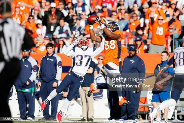 Demaryius Thomas of the Denver Broncos completes a fourth quarter reception against Alfonzo Dennard of the New England Patriots during the AFC...