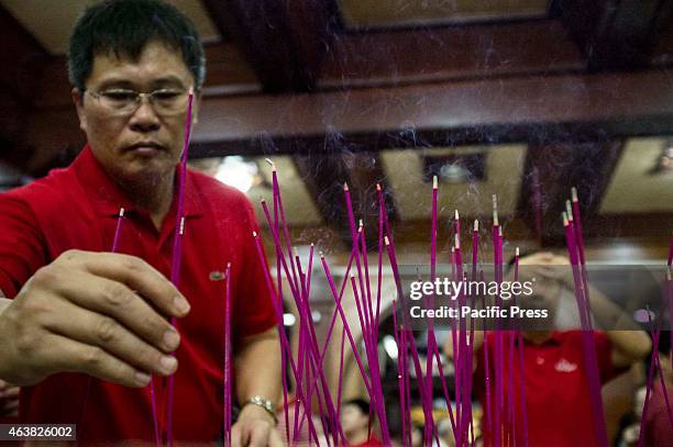 Family members put their incense in a golden pot located at the center of the shrine after praying.