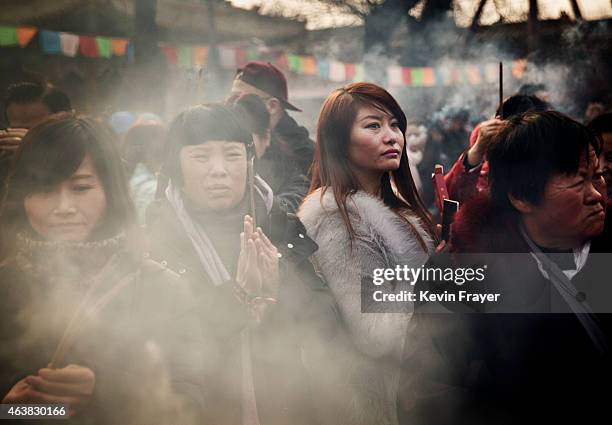 February 19: A Chinese women hold incense while praying at the Yonghegong Lama Temple during celebrations for the Lunar New Year February 19, 2015 in...