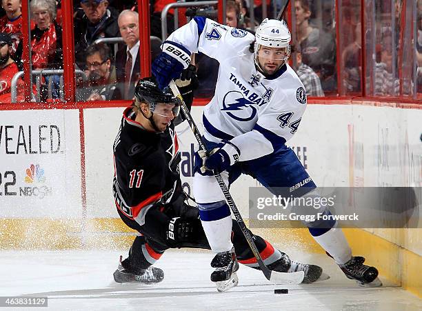 Jordan Staal of the Carolina Hurricanes goes down on the ice while battling for the puck with Nate Thompson of the Tampa Bay Lightning during their...