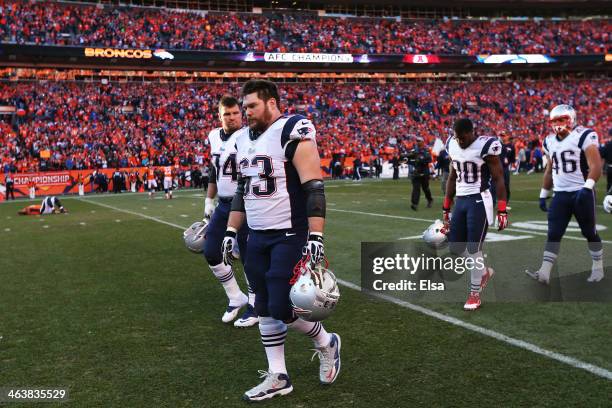 Dan Connolly of the New England Patriots and teammates walk off of the field after loosing to the Denver Broncos 16 to 26 during the AFC Championship...