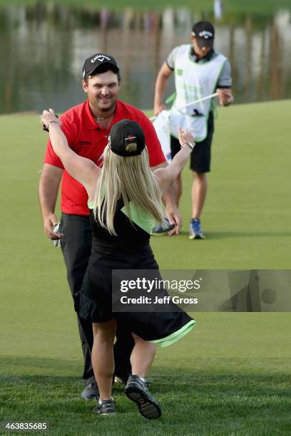 Patrick Reed is congratulated by his wife on the 18th green after winning the Humana Challenge in partnership with the Clinton Foundation on the...