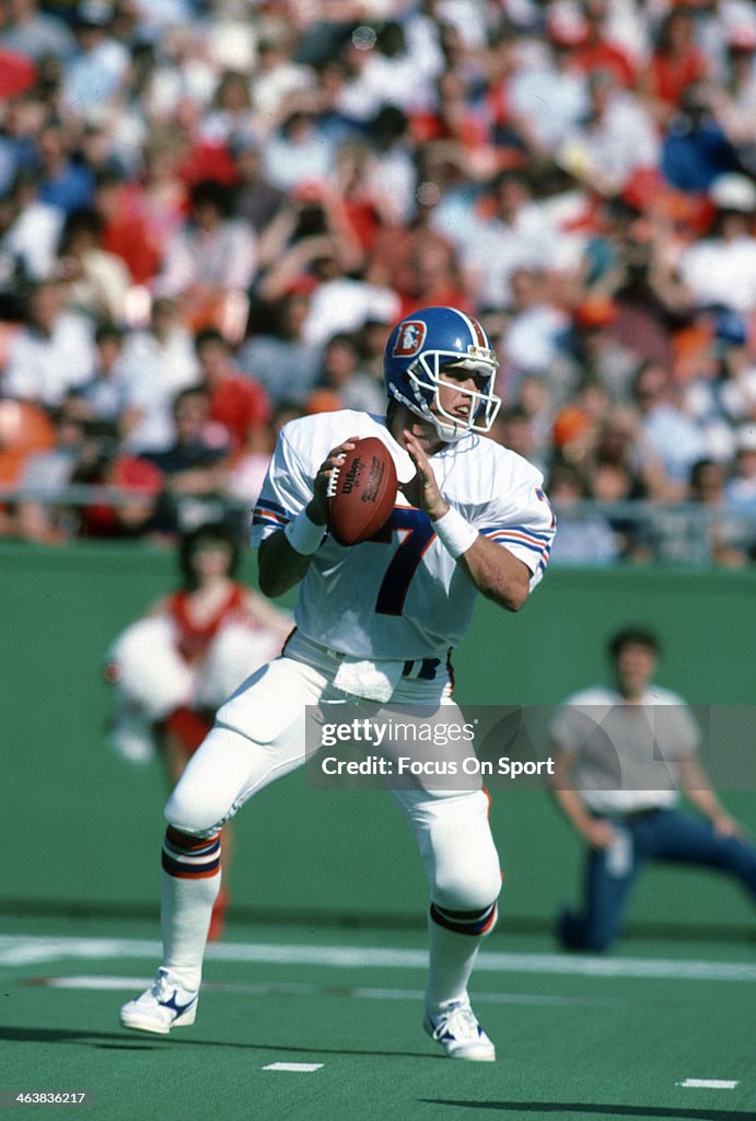 John Elway of the Denver Broncos drops back to pass against the... News