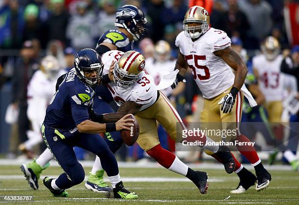 Quarterback Russell Wilson of the Seattle Seahawks is hit by inside linebacker NaVorro Bowman of the San Francisco 49ers in the first half during the...