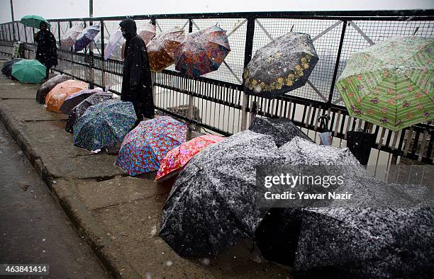 Kashmir vendor sells umbrellas amid a fresh snowfall on February 19, 2015 in Srinagar, Indian Administered Kashmir, India. Several parts of the...