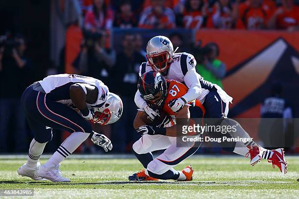Eric Decker of the Denver Broncos completes a reception for a first down as Alfonzo Dennard of the New England Patriots tackles in the first quarter...