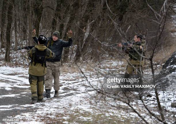 Two pro-Russian seperatists stop a man holding his arms up in the eastern Ukrainian city of Uglegorsk, 6 kms southwest of Debaltseve, on February 19,...