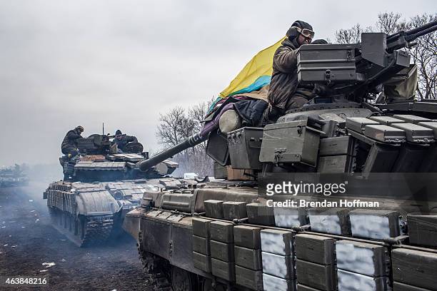 Ukrainian soldiers drive tanks along the road leading out of Debaltseve on February 19, 2015 in Artemivsk, Ukraine. Ukrainian forces have begun...