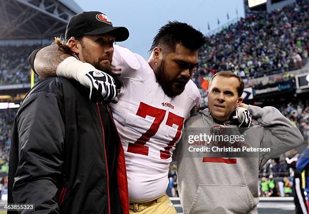 Guard Mike Iupati of the San Francisco 49ers is helped off the field in the second quarter while taking on the Seattle Seahawks during the 2014 NFC...