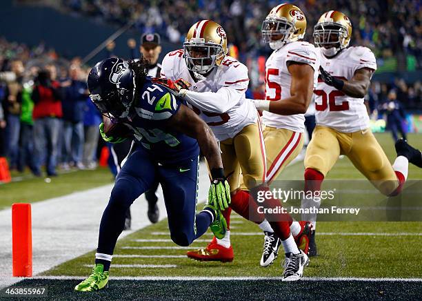 Running back Marshawn Lynch of the Seattle Seahawks scores a 40-yard touchdown against cornerback Tarell Brown of the San Francisco 49ers in the...