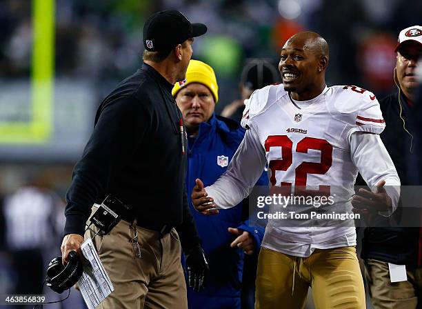 Cornerback Carlos Rogers of the San Francisco 49ers talks with head coach head coach Jim Harbaugh during the 2014 NFC Championship at CenturyLink...