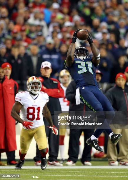 Strong safety Kam Chancellor of the Seattle Seahawks makes an interception in the fourth quarter in front of wide receiver Anquan Boldin of the San...