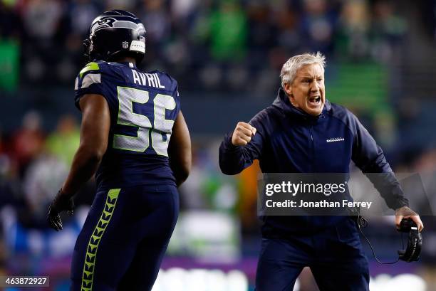 Head coach Pete Carroll and defensive end Cliff Avril of the Seattle Seahawks celebrate in the fourth quarter while taking on the San Francisco 49ers...