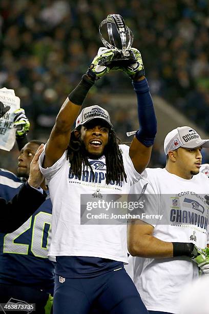 Cornerback Richard Sherman of the Seattle Seahawks celebrates with the George Halas Trophy after the Seahawks defeat the San Francisco 49ers 23-17 in...