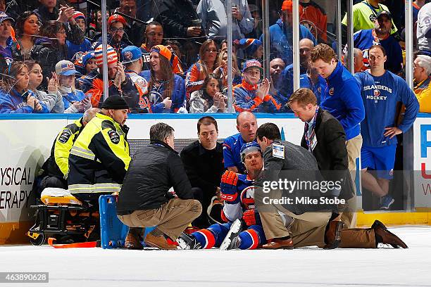 Mikhail Grabovski of the New York Islanders is tended to by medical staff after being checked by Eric Nystrom of the Nashville Predators at Nassau...