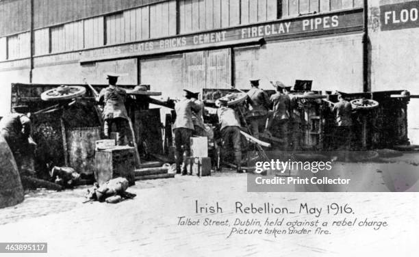 English troops under fire in Talbot Street, Anti-English Irish uprising, Dublin, May 1916. English troops under fire behind a barricade of cars,...