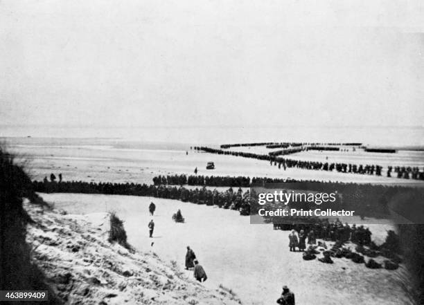 British retreat from Dunkirk, World War 2, 1940. British troops forming into winding queues waiting to board small boats which ferried them to larger...