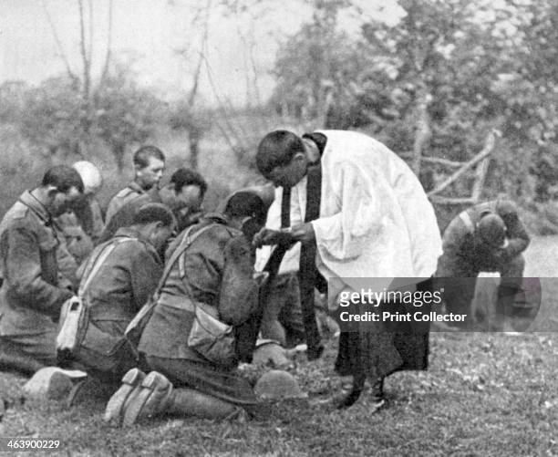 New Zealand troops taking Holy Communion administered by an Army chaplain in the open air. World War.