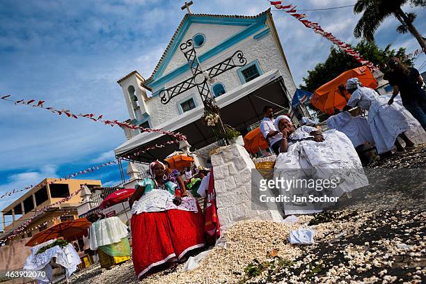Baiana women perform the popcorn bath, an Afro-Brazilian spiritual cleansing ritual, in front of the St. Lazarus church on January 30, 2012 in...