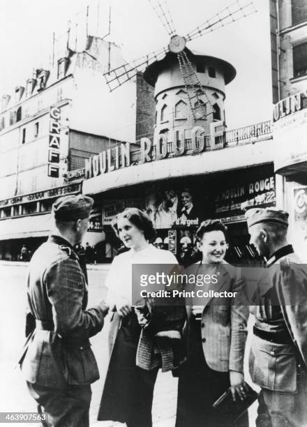 German soldiers chatting up French women outside the Moulin Rouge, occupied Paris, June 1940.