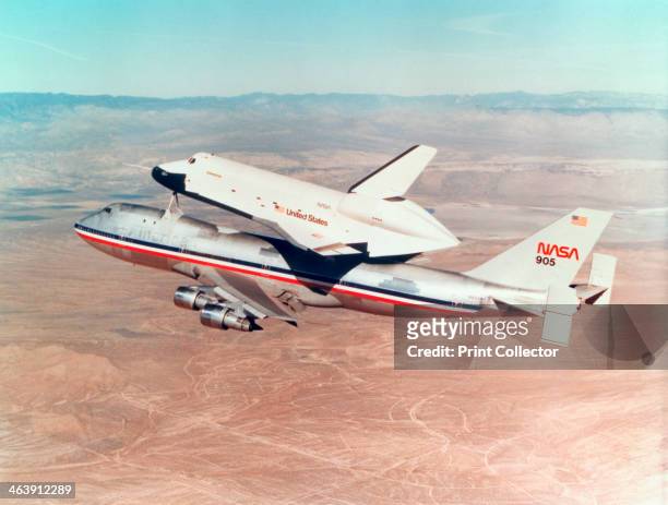 Space Shuttle Orbiter mounted on top of a Boeing 747 carrier aircraft, 1977. The Shuttle Orbiter is often transported this way from landing site to...