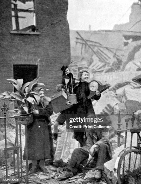 Londoners made homeless by a German air raid during the Blitz, World War II, October 1940. Holding some treasured possessions recovered from the...