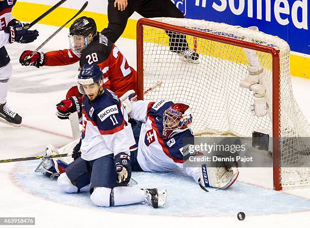 Forward Lawson Crouse of Canada battles in front of the net against defenceman Matus Holenda and goaltender Denis Godla of Slovakia during the 2015...