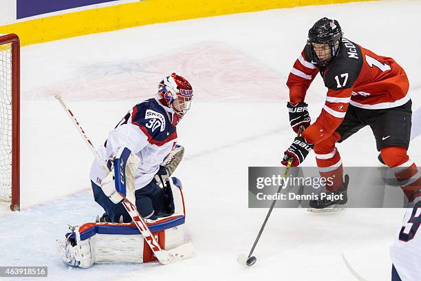 Forward Connor McDavid of Canada deflects the puck against goaltender Denis Godla of Slovakia during the 2015 IIHF World Junior Championship on...