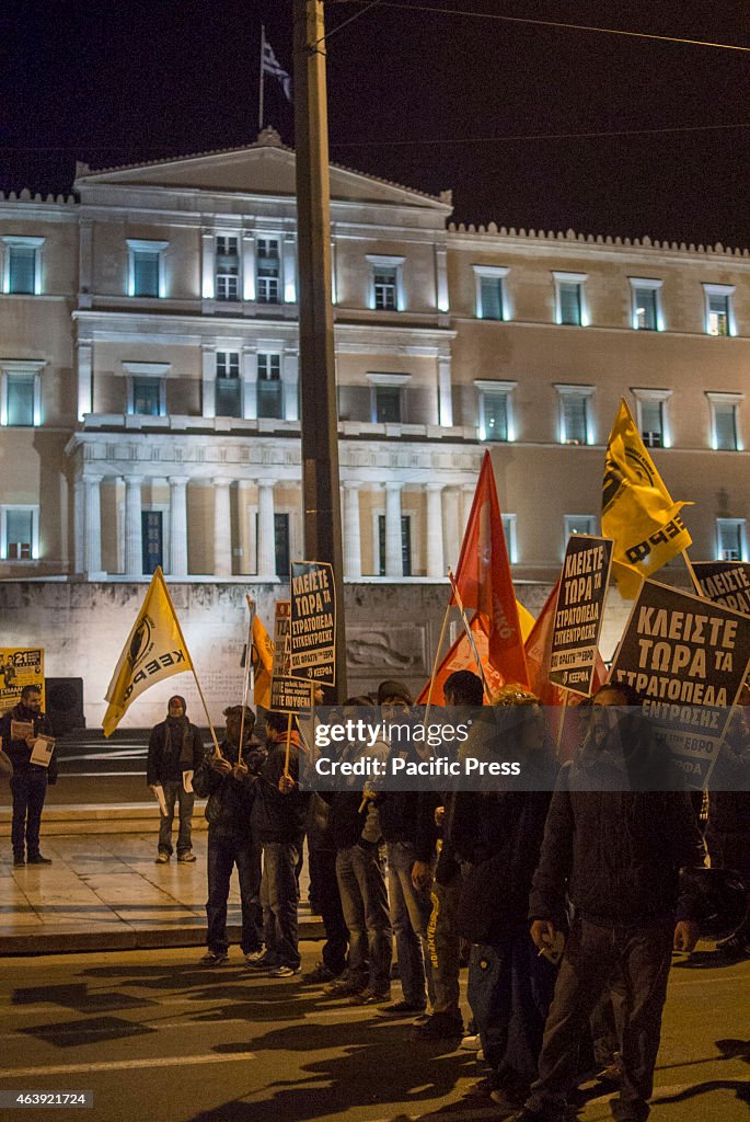 Demonstrators stand in front of the Greek parliament...