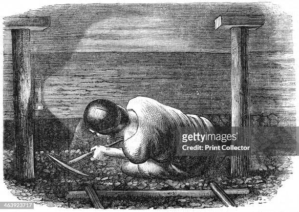 Coal miner working a narrow seam, c1864. The miner is crouching on the floor and, with a pickaxe, is holing out or scuffling out the coal. He is...