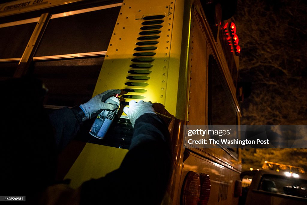 Cesar Vinueza-Leon sprays starter fluid to get a diesel school bus running in Derwood, Maryland...