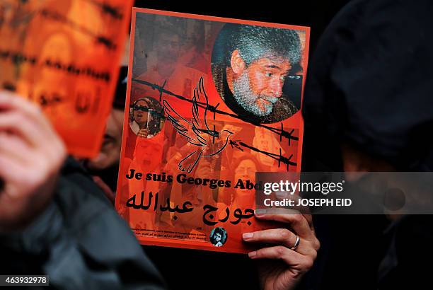 Supporter of Lebanese militant Georges Ibrahim Abdallah holds up a placard bearing his portrait and a slogan in French and Arabic reading: 'I am...