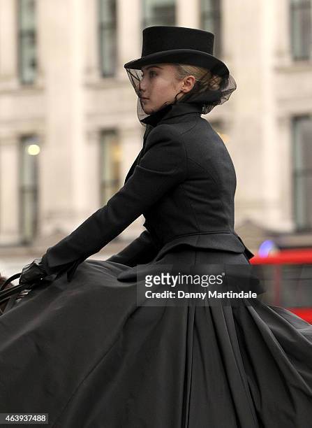Model wearing an dress designed by Sarah Burton for Alexander McQueen sits on a horse outside a memorial service for Professor Louise Wilson during...