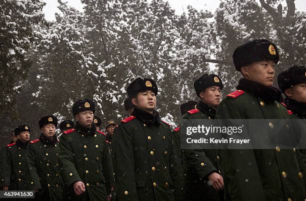 Chinese paramilitary police officers march during a light snowfall while guarding on the grounds of the Temple of Heaven during Spring Festival...