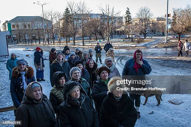 Local residents gather to receive humanitarian aid outside a damaged supermarket on the central square on February 20, 2015 in Debaltseve, Ukraine....