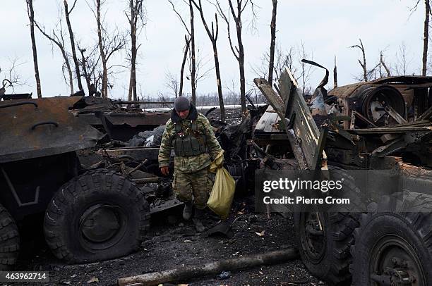 Pro-Russian rebel collects belongings of Ukrainian soldiers on the outskirt of the town on February 20, 2015 in Debltseve, Ukraine. The strategic...