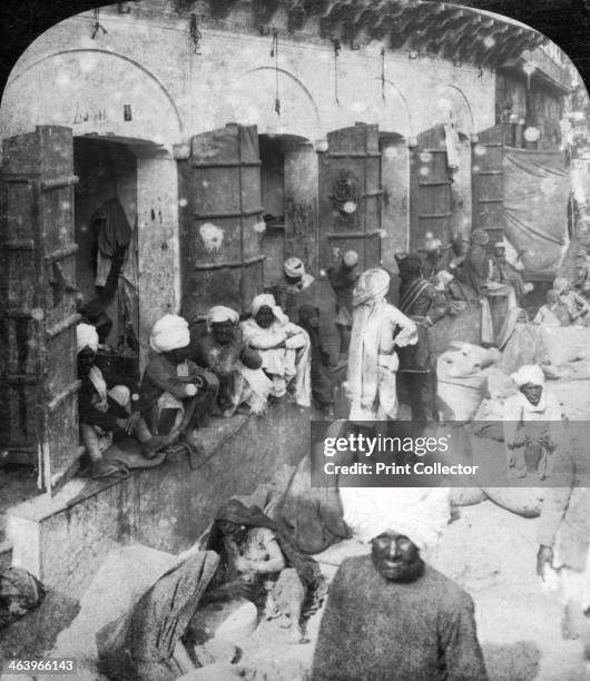 Indian women grinding corn between two round stones, Delhi, India, 1900s. Stereoscopic card. Detail.